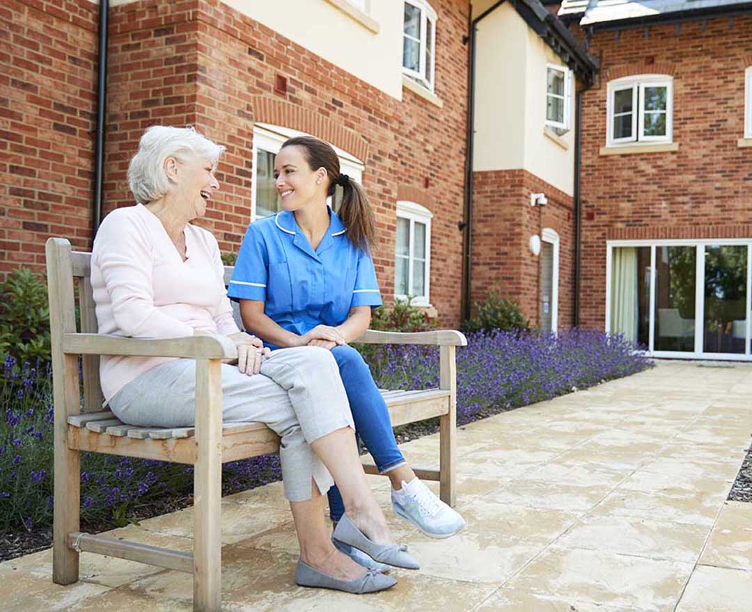 A caregiver assisting an elderly client with a medication administration record on a tablet
